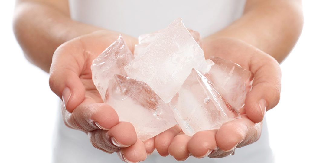 Woman holding many ice cubes on white background, closeup